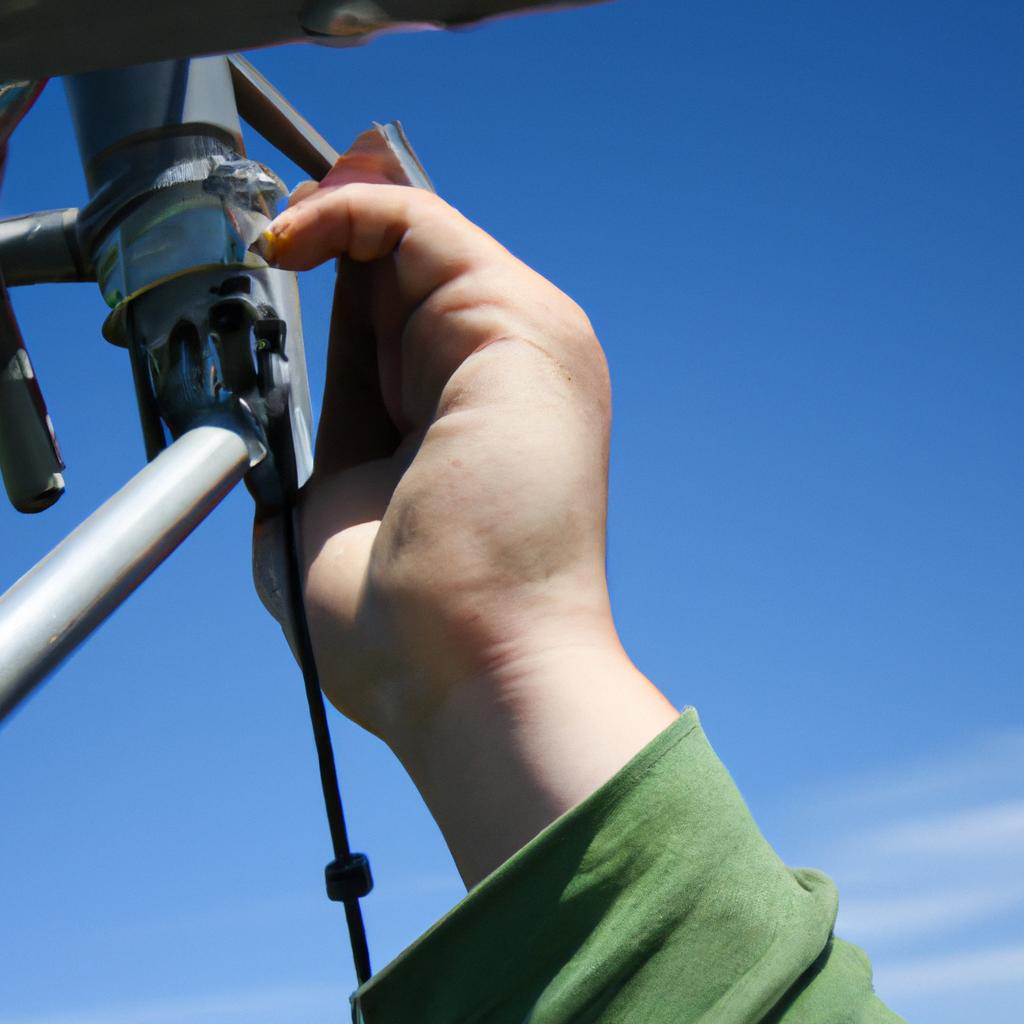 Person adjusting radio antenna outdoors